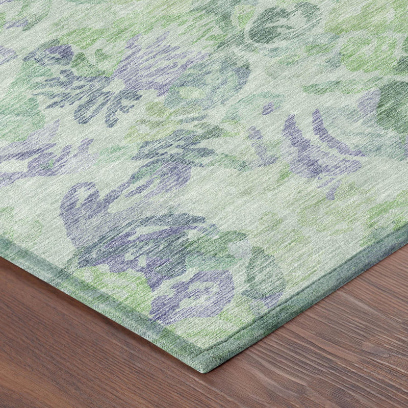 Corner detail of floral area rug with mint green ground and purple-blue motif