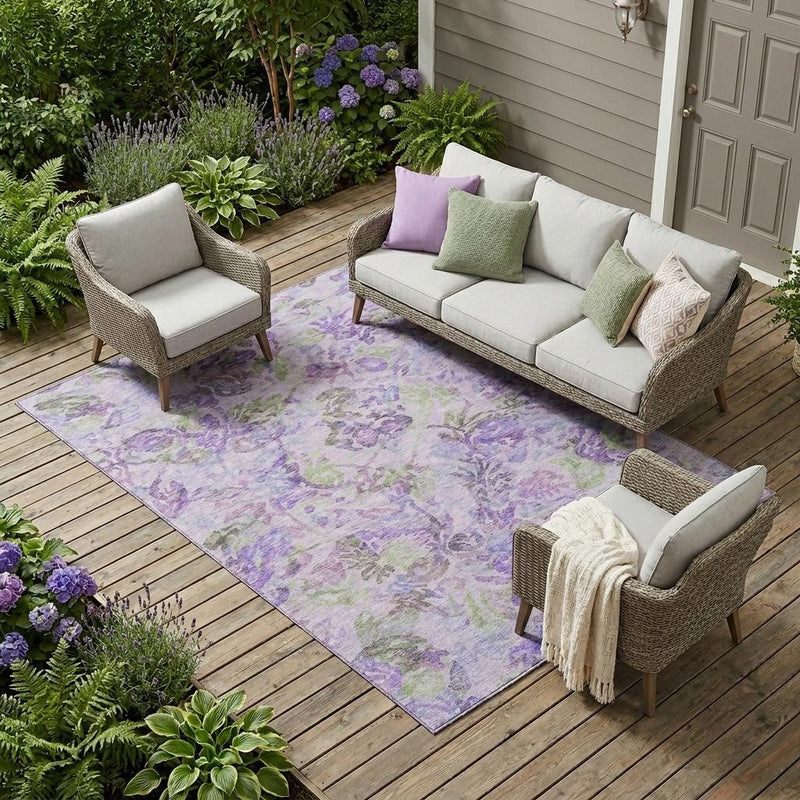 Indoor outdoor floral area rug with plum, purple, and green blossoms on light background