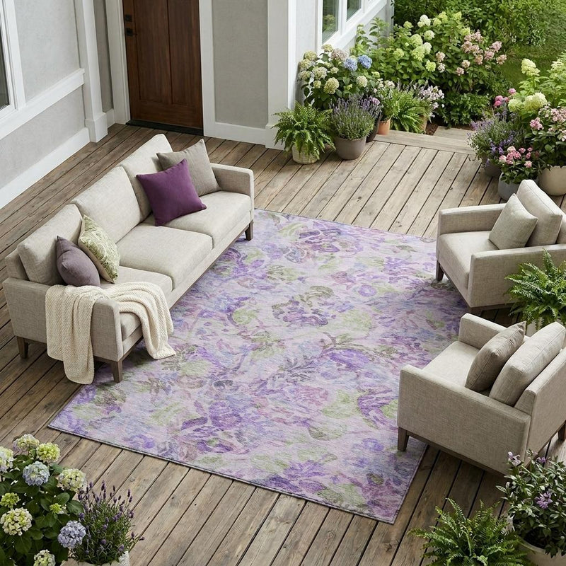 Lavender floral area rug laid under patio furniture, featuring purple and green motifs