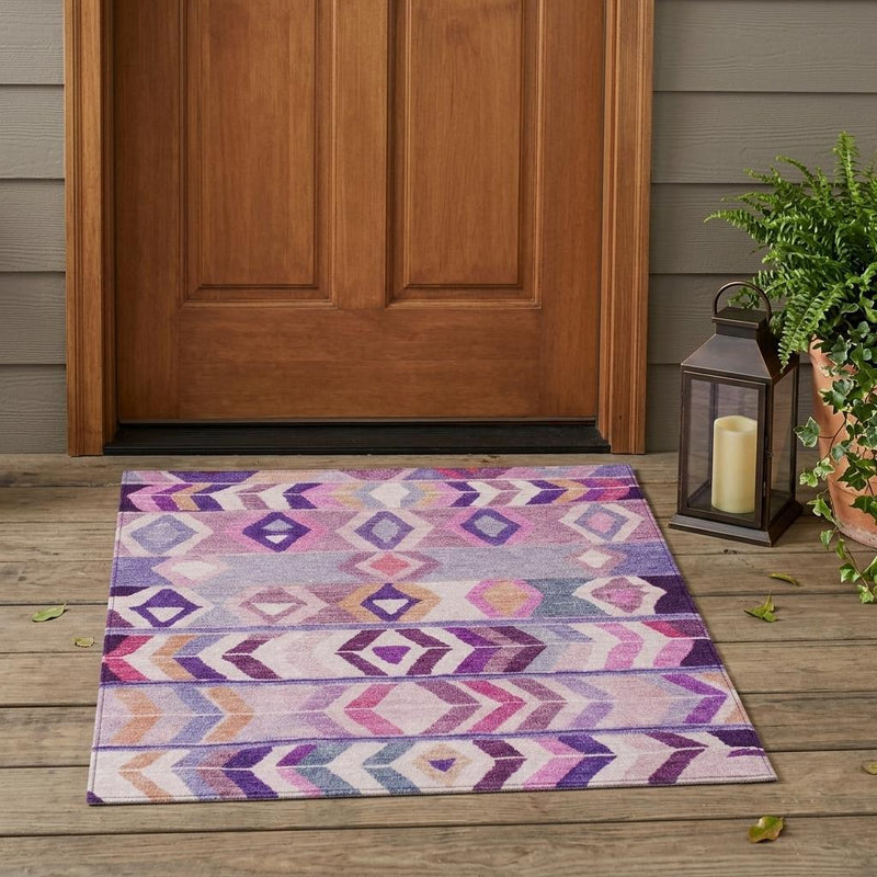 Purple and lavender tribal area rug laid on wood floor near entry door
