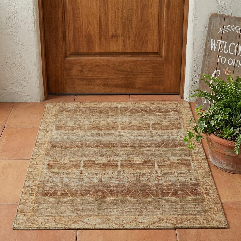 Tan area rug with distressed tribal pattern on floor, warm cream and copper tones