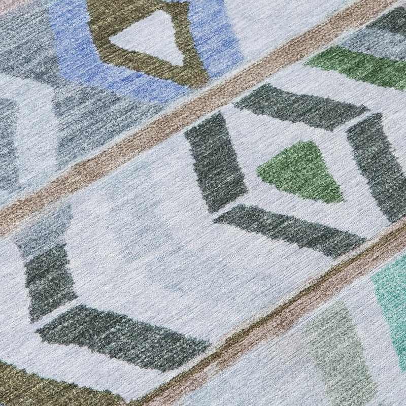 Beige and gray area rug corner with green, blue, and black geometric square pattern.