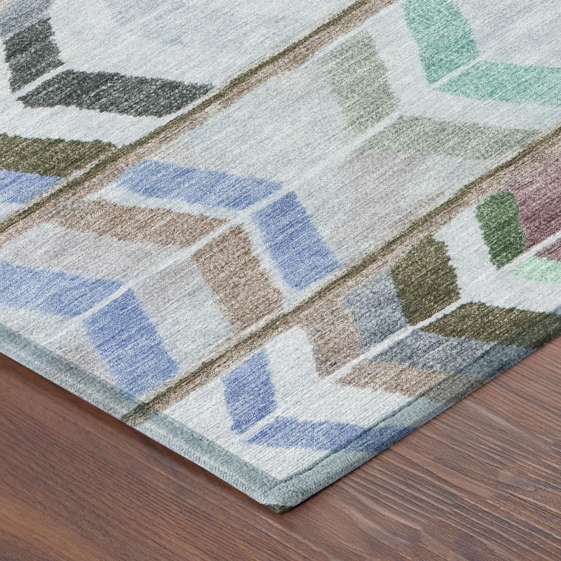 Beige area rug edge with multicolor chevron blocks in green, blue, and maroon tones.
