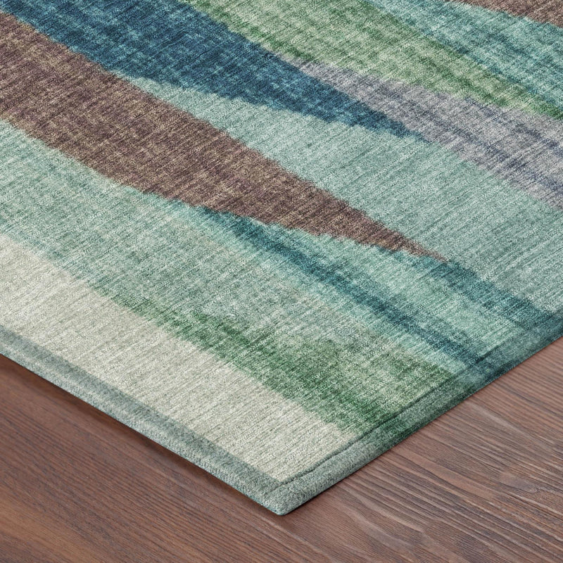 Corner close-up of striped rug edge with teal, green, beige, and brown bands