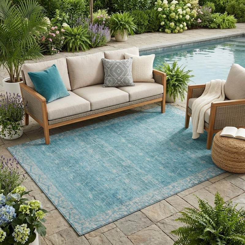 Rectangular blue and teal tribal area rug with distressed pattern, flat surface.