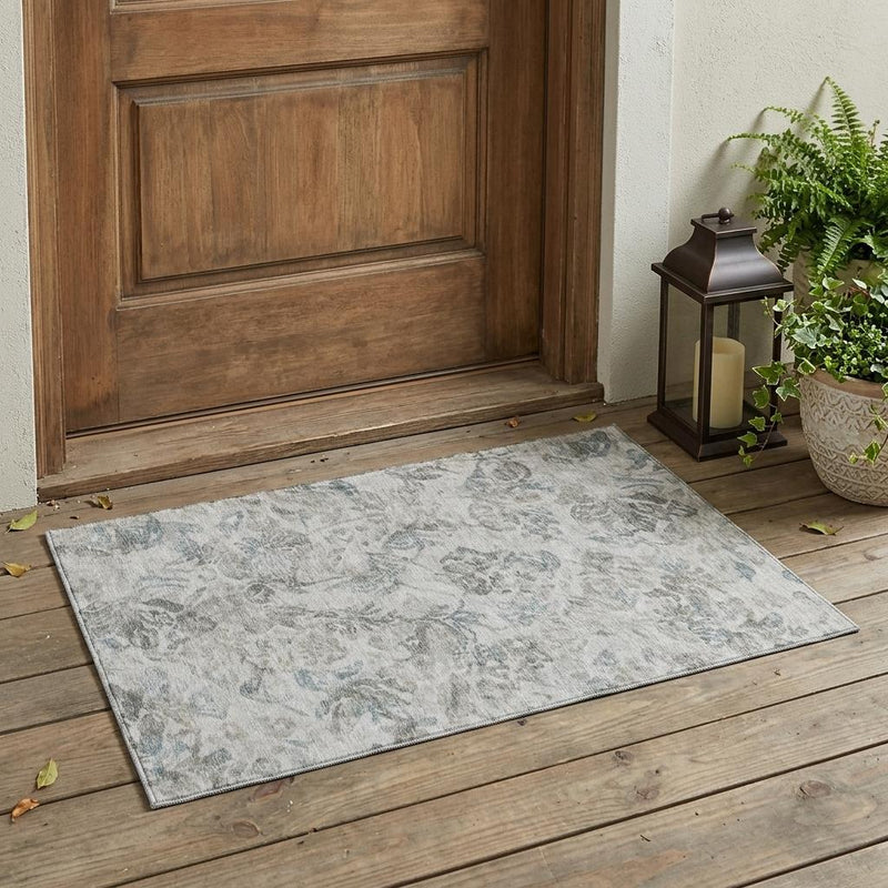 Rectangular light taupe area rug with teal floral pattern and flat weave border