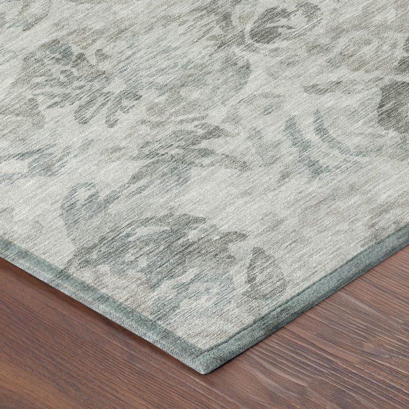 Corner detail of light taupe area rug with teal floral pattern and low-profile border