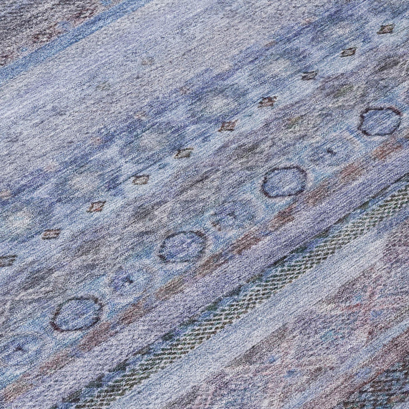 Close-up of blue area rug with lilac-toned stripes and small loop motifs