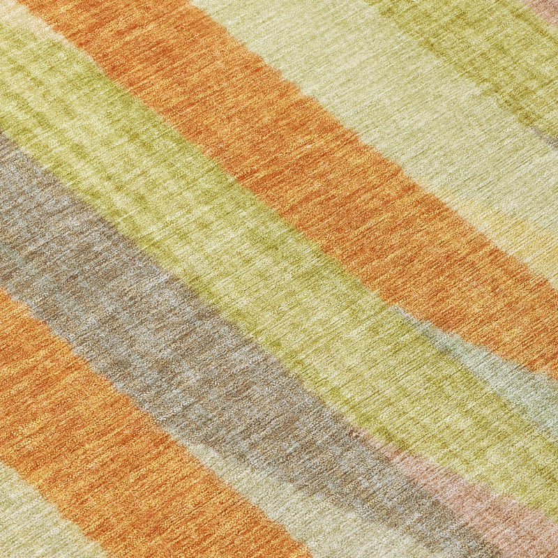 Close-up of round area rug stripes with textured weave in orange, gold, and green tones.