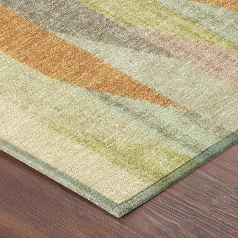 Corner view of round striped rug with textured surface and muted green, gray, and orange stripes.