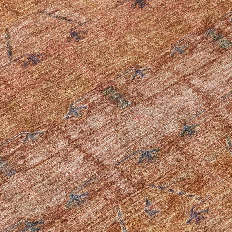 Rust-orange rug close-up with textured weave and scattered blue tribal markings.
