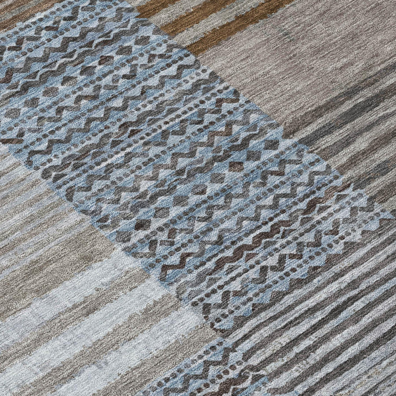 Rectangular area rug close-up with gray stripes and blue dotted geometric pattern