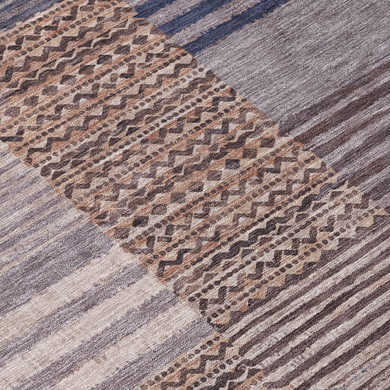 Close-up of gray and brown geometric striped patchwork area rug
