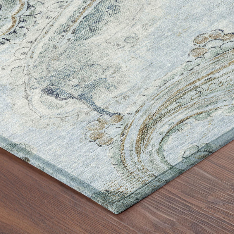 Corner of a light blue paisley area rug with distressed cream and teal accents