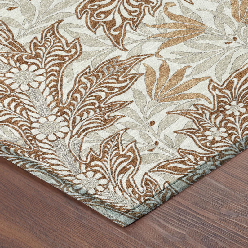Corner view of botanical area rug with orange and khaki leaf pattern on light fabric