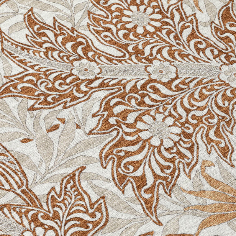Close-up of botanical area rug showing orange and khaki floral and vine details on light