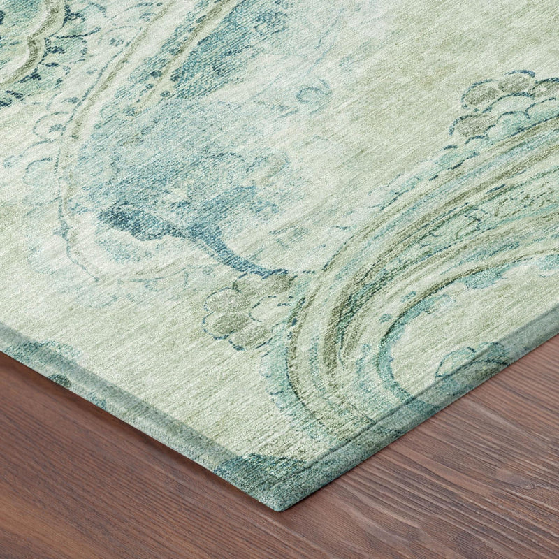 Corner detail of round rug with sage green ground and blue paisley border