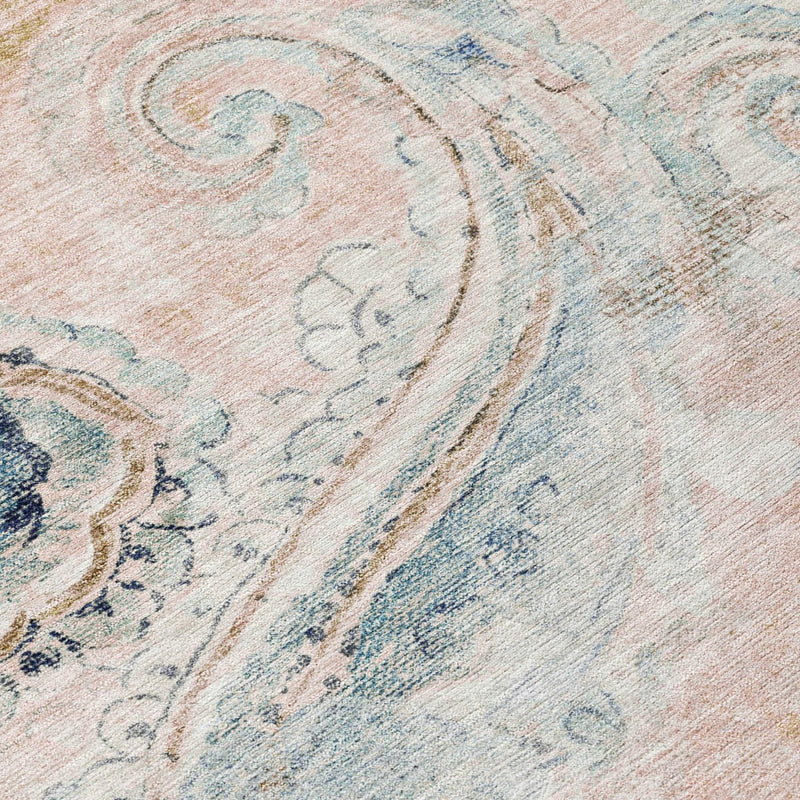Close-up of pink and light blue paisley rug texture with faded swirls
