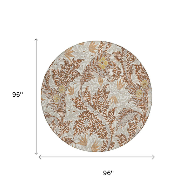 Round 96-inch area rug with orange and khaki botanical leaf design