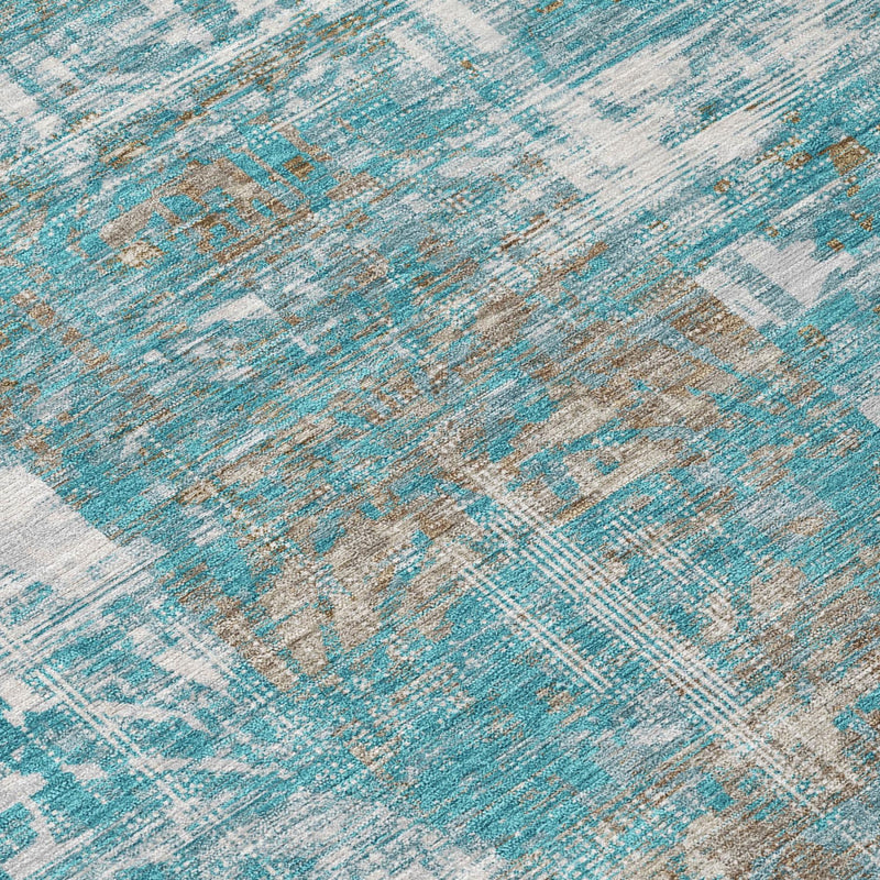 Teal blue abstract area rug close-up of distressed woven pattern with tan accents