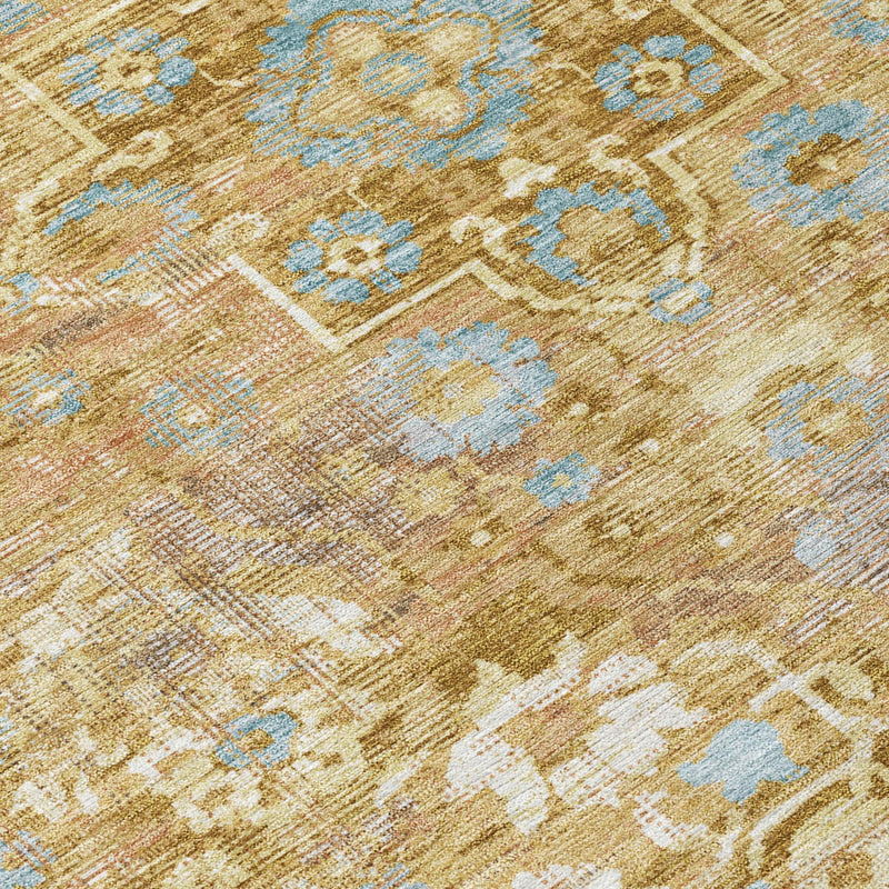 Close-up of round rug fabric with gold and copper distressed print and light blue motifs