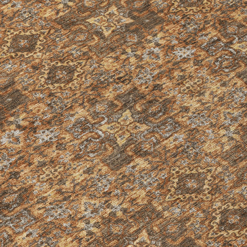 Close-up damask area rug texture in orange, brown, and gray tones