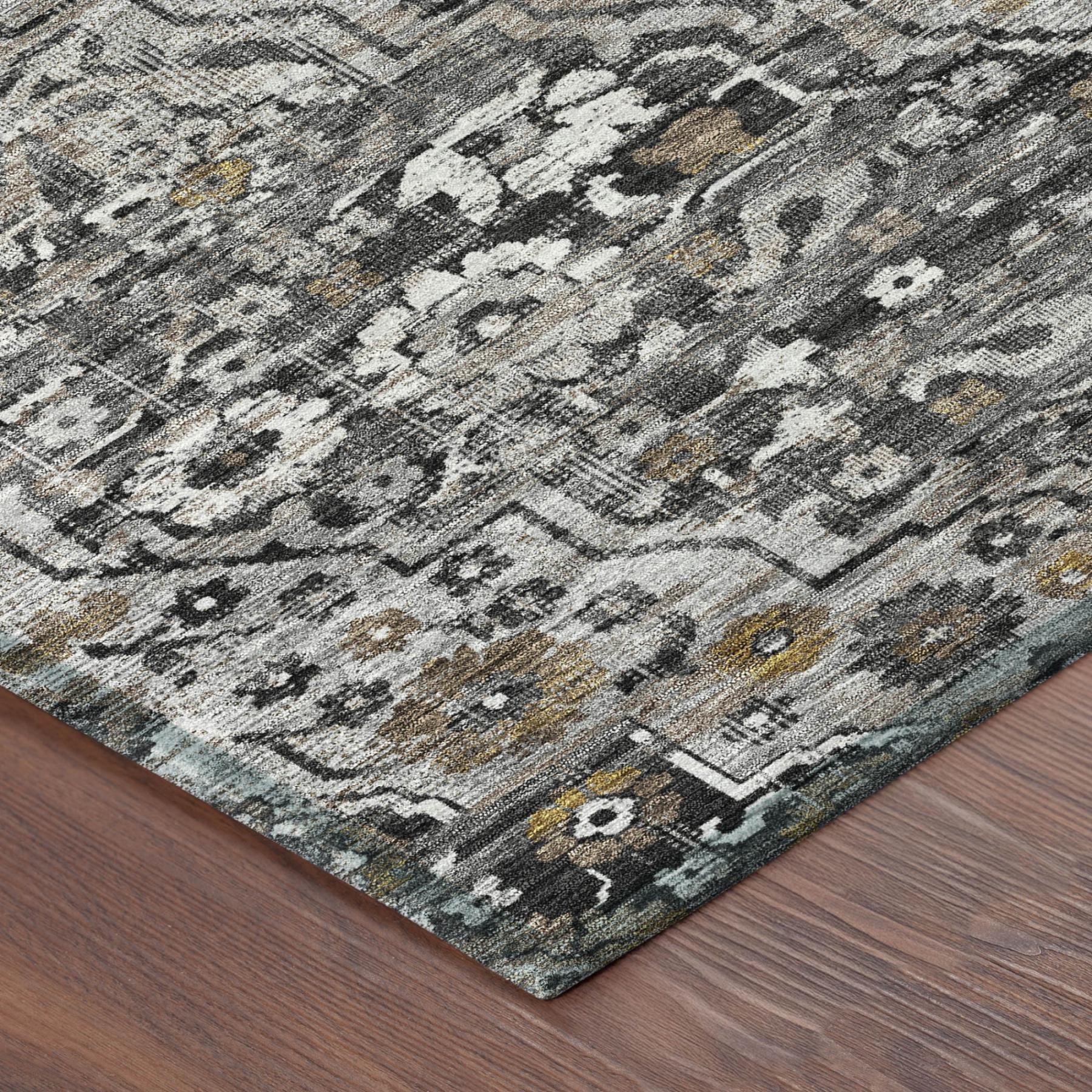 Gray and black floral medallion area rug with worn texture, corner view