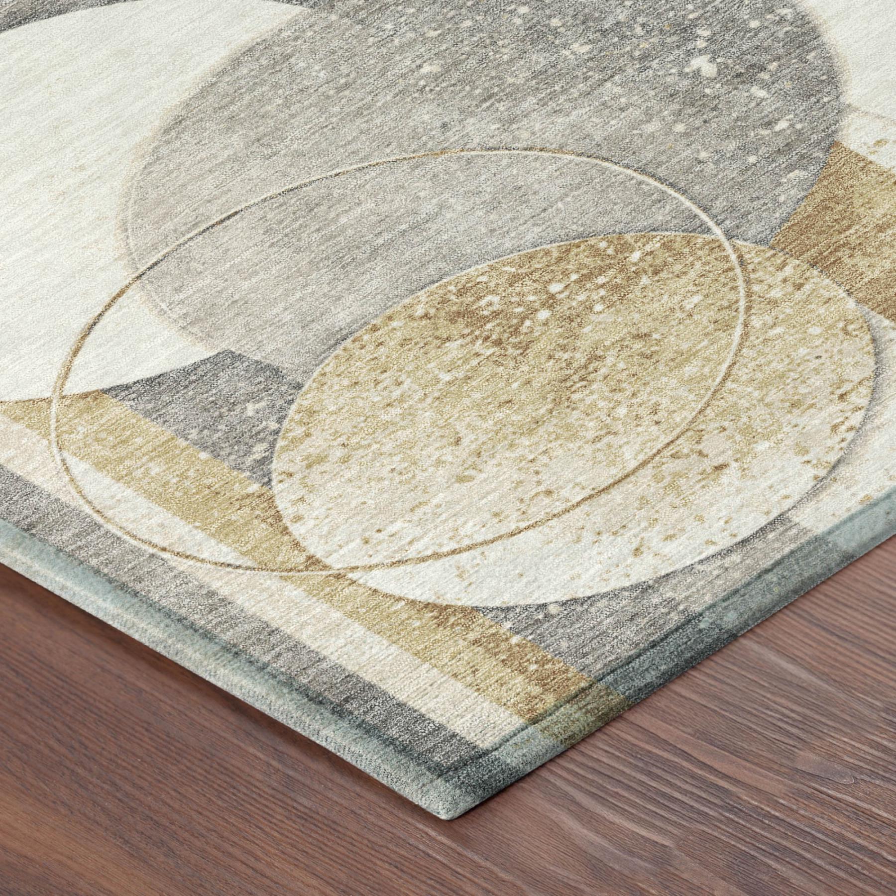 Corner of geometric rug with gray, cream, and gold textured oval and striped circles