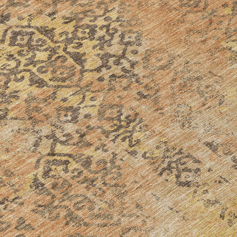 Close-up of abstract rug pattern in tan, rust orange, and dark gray speckles