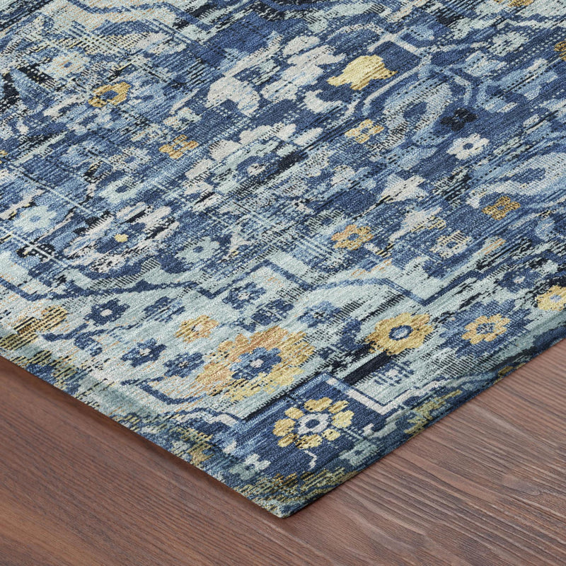 Corner view of blue and navy floral medallion area rug on wood floor