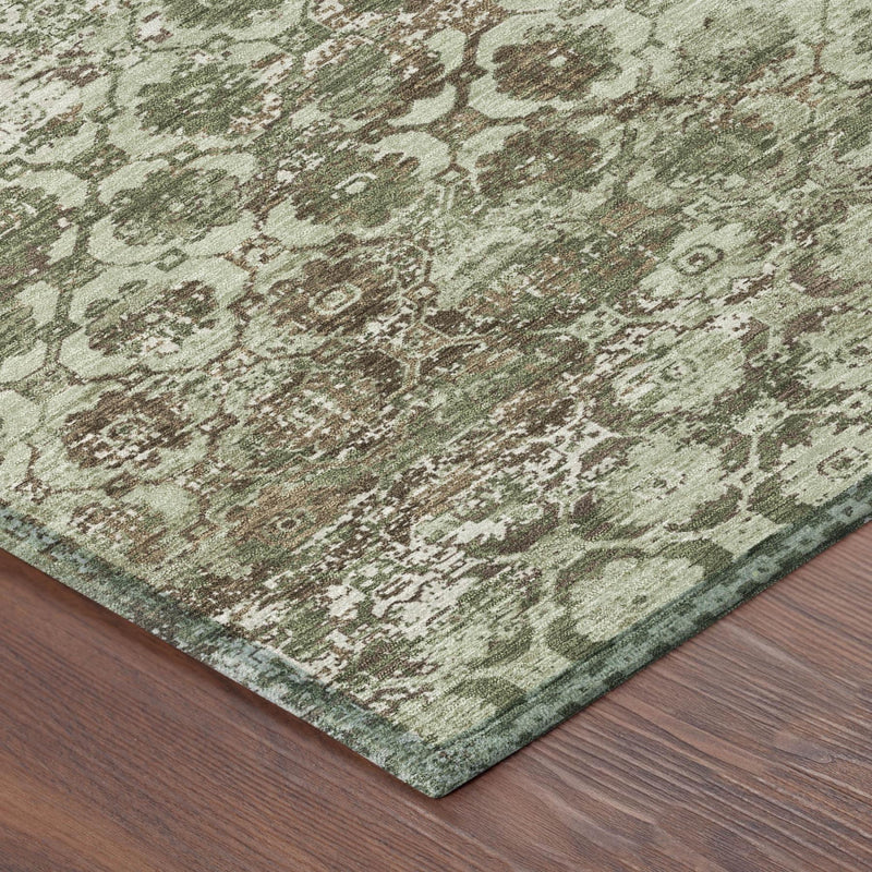 Olive green floral medallion area rug with distressed texture, corner folded into view.