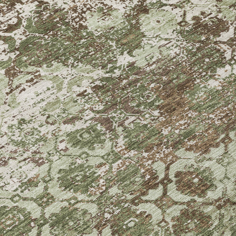 Olive green area rug close-up with distressed medallion motifs and speckled finish.