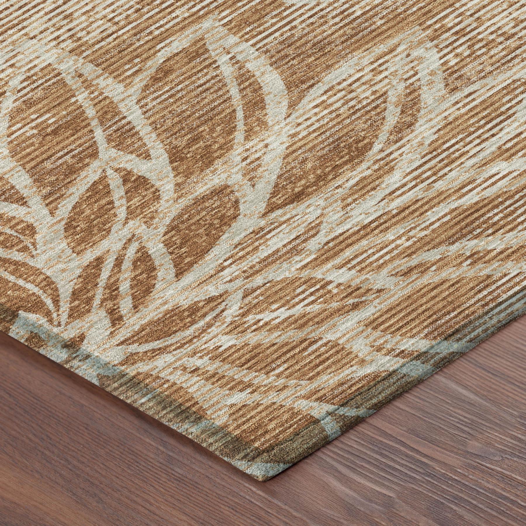 Orange and rust floral rug corner with low-profile edge and woven texture