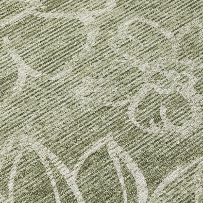 Olive green rug close-up with white floral linework and fine textured backing