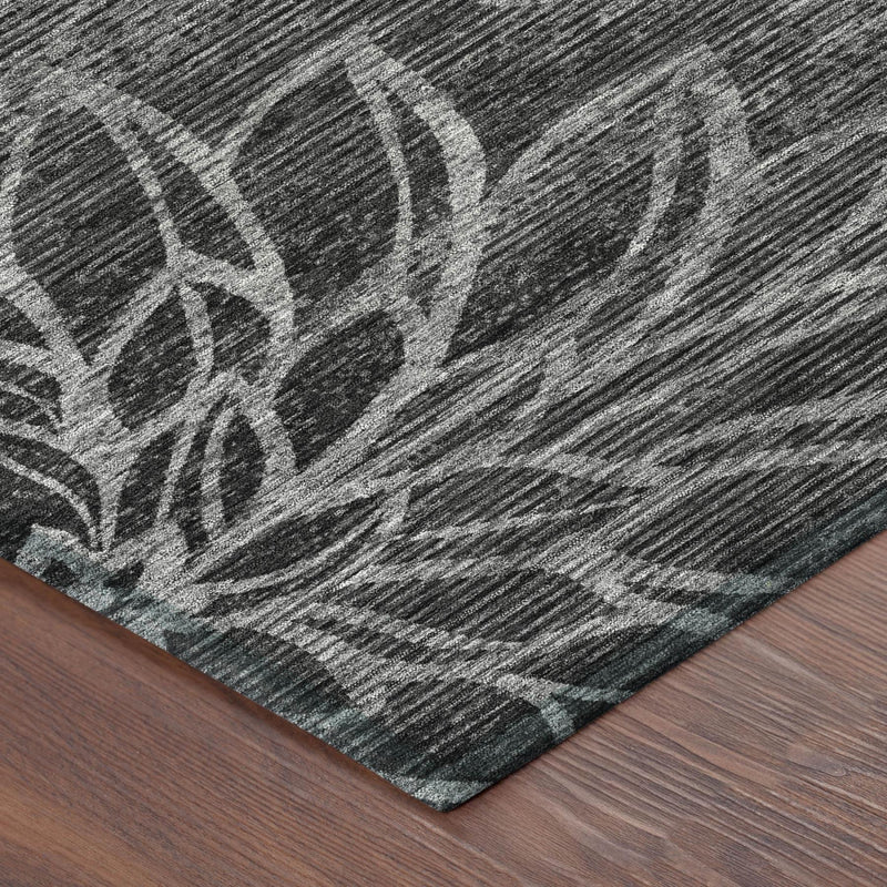 Area rug corner showing dark graphite lines and floral motifs with short flat pile.