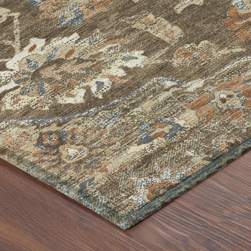Corner detail of round brown washable area rug with blue, orange, and cream floral pattern