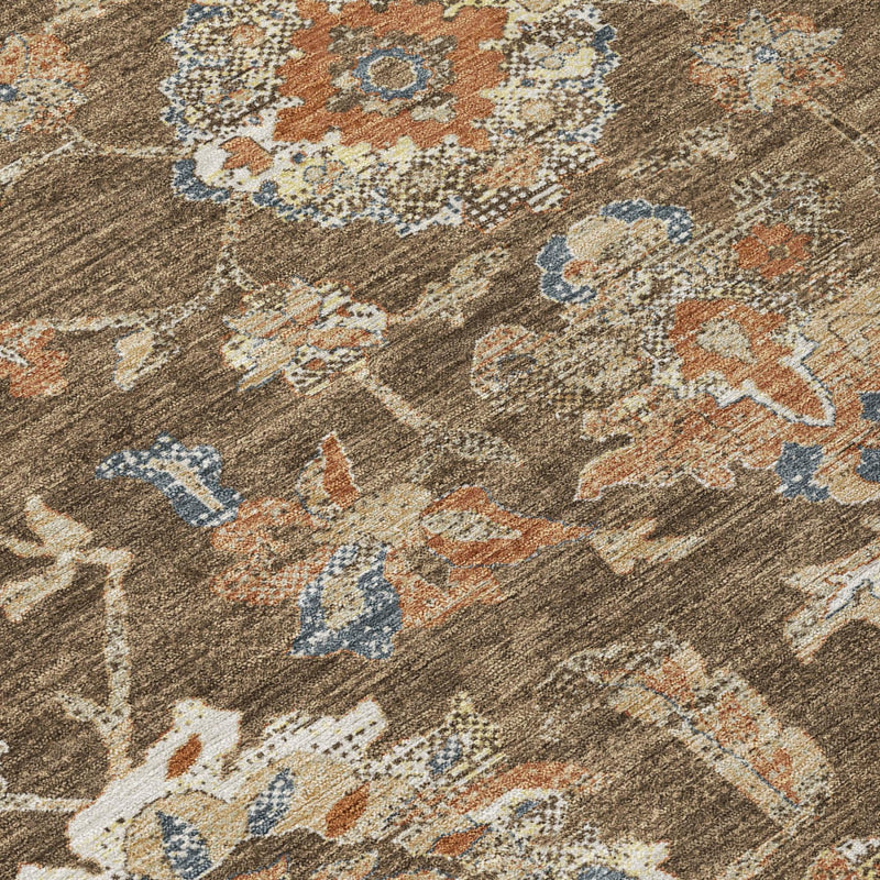 Close-up of brown rug texture with distressed floral medallion motifs in blue and orange