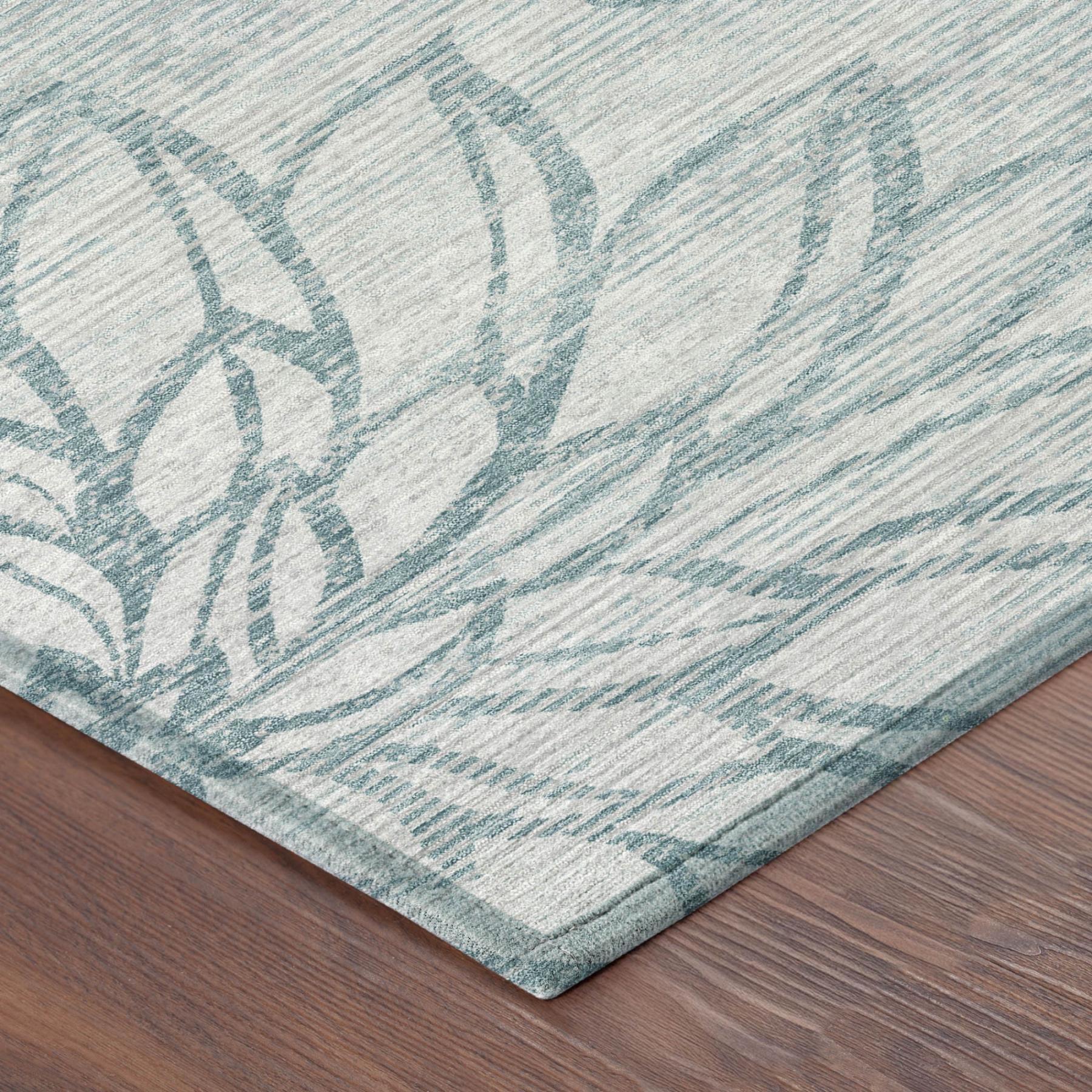 Corner detail of light gray area rug with light blue floral pattern and flat weave