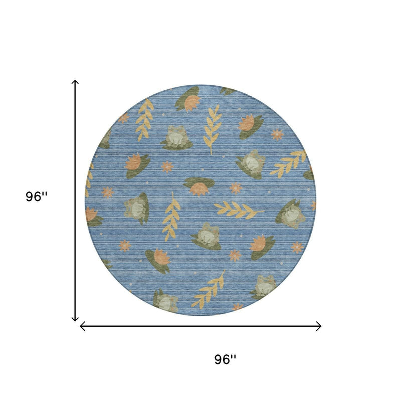 Round blue area rug with scattered olive, green, and orange leaf silhouettes