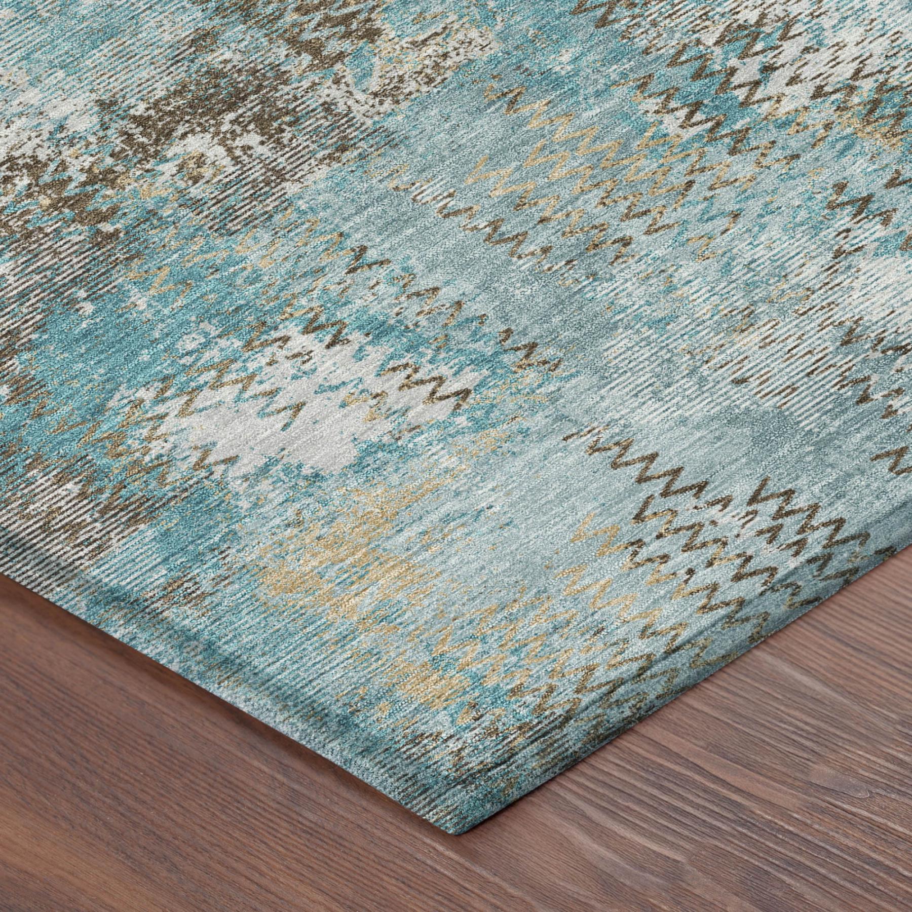 Corner view of abstract area rug in teal blue and pewter with zigzag stitched edge detail