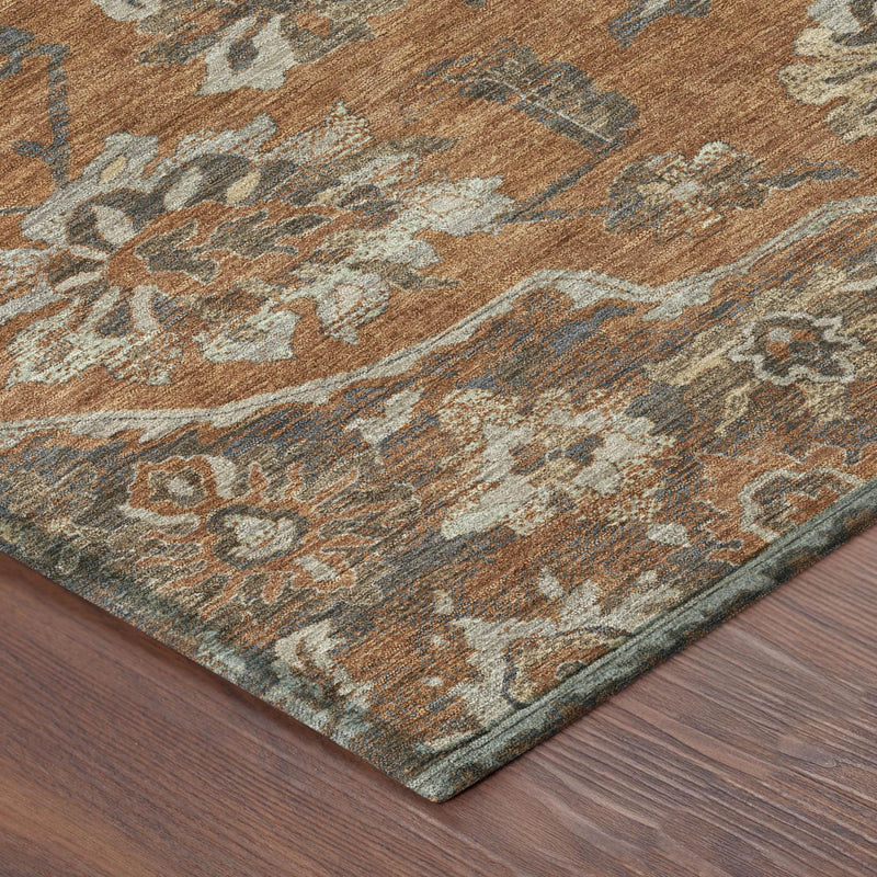 Corner of orange, brown, and gray floral medallion area rug with teal edging