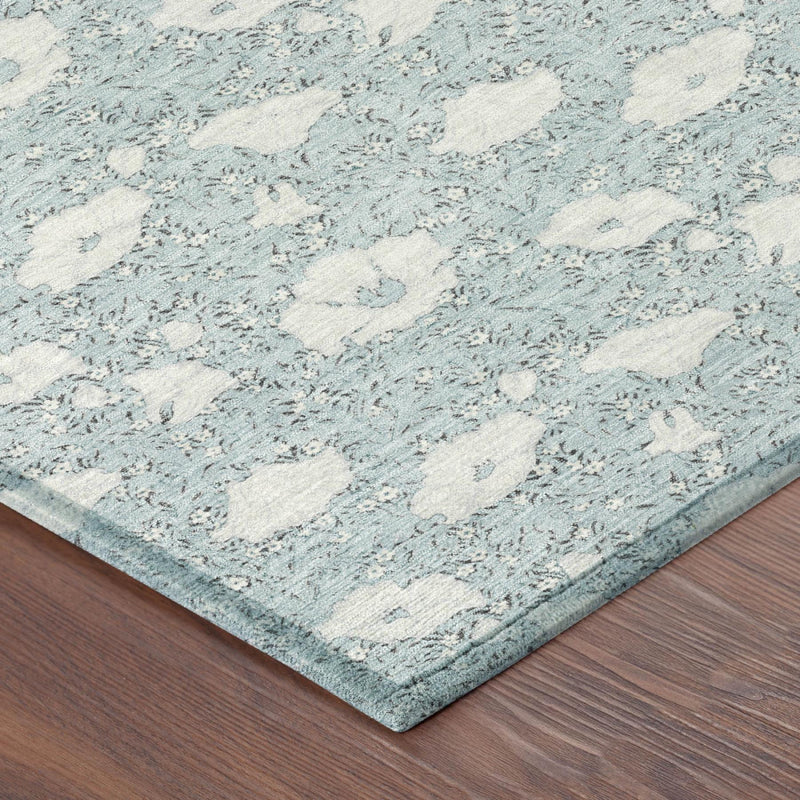 Corner view of sky blue area rug with textured light-blue floral pattern