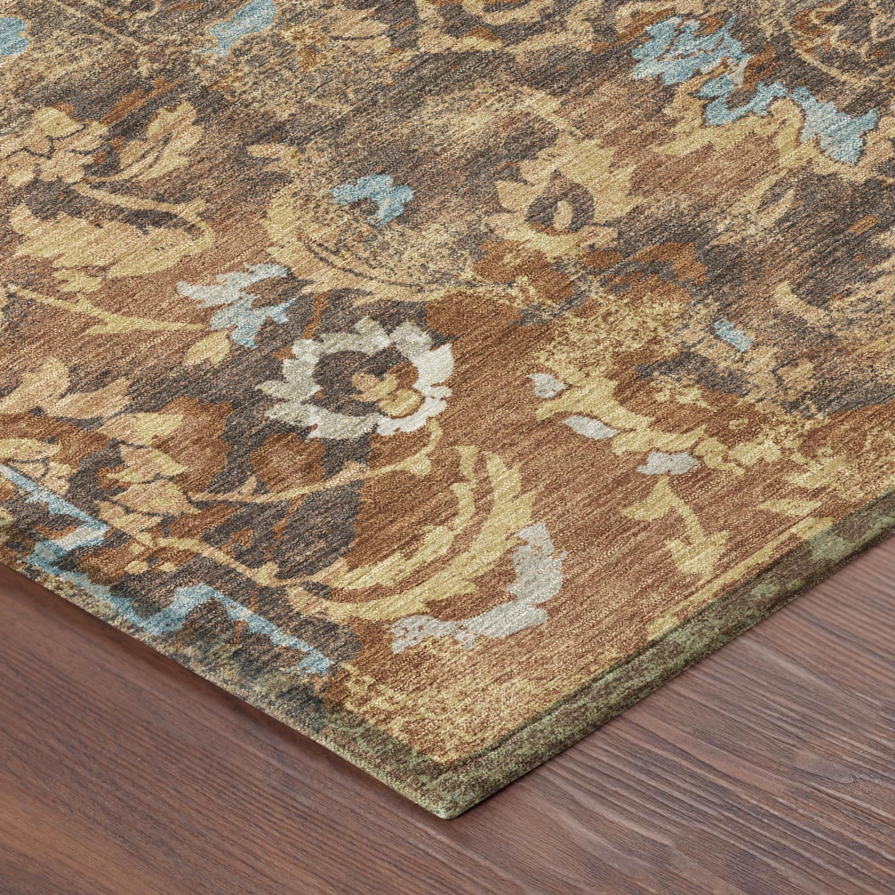 Floral area rug with rust, tan, gray, and blue distressed pattern, corner view