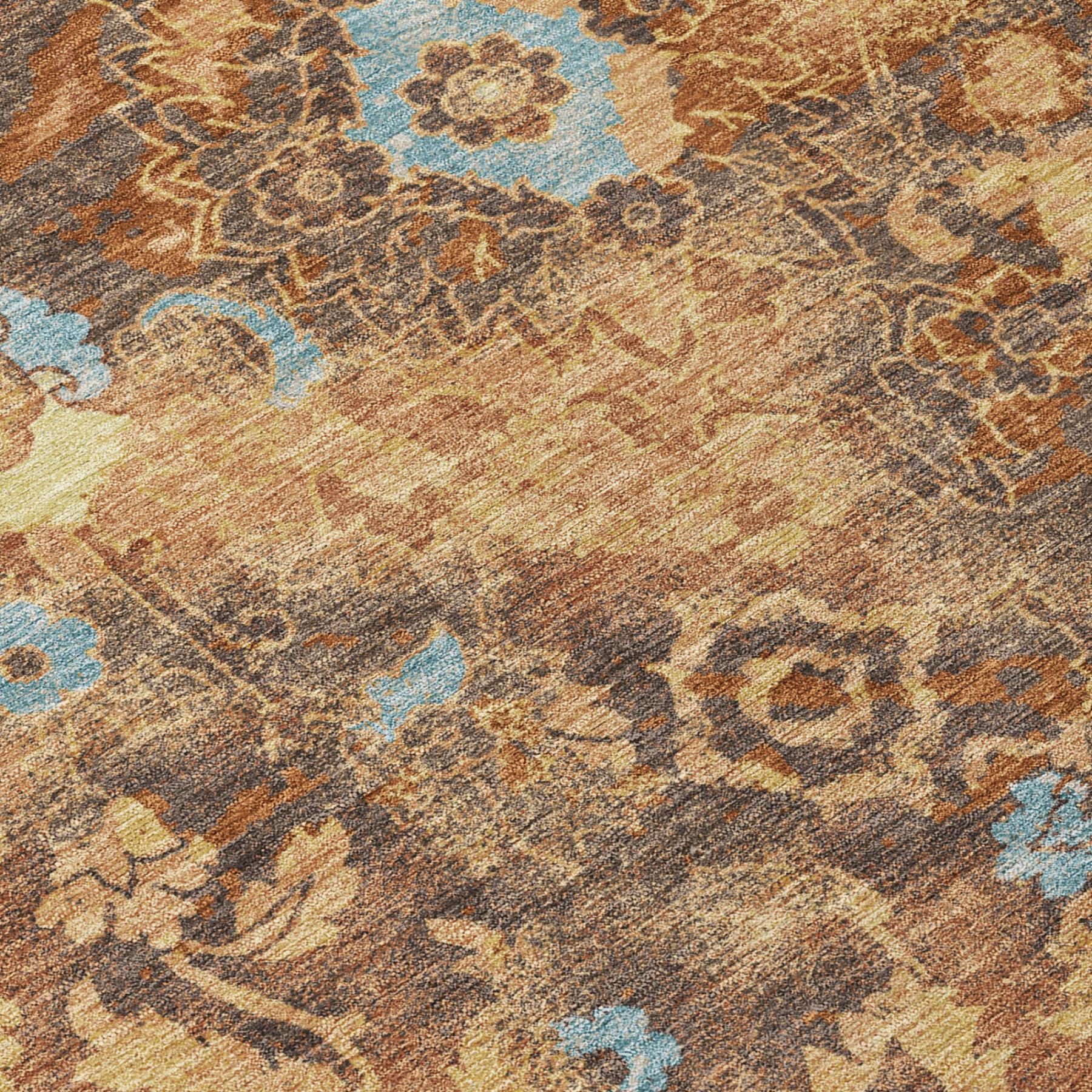 Floral area rug with orange-rust, tan, gray, and blue distressed motif, close-up