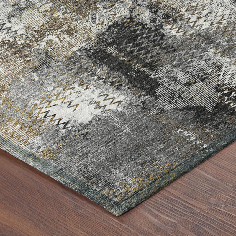 Close-up of round abstract rug edge: gray and charcoal with cream and mustard zigzags