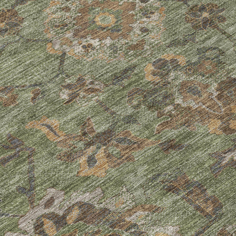 Olive green rug close-up with textured, distressed green floral medallion pattern.
