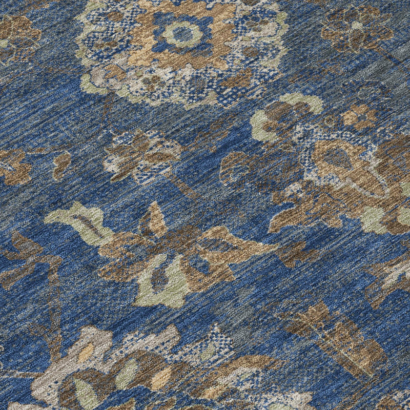 Blue area rug with cream and gold floral motifs, distressed texture