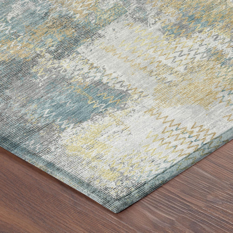 Corner view of abstract area rug with silver-gray, blue, and yellow brushy pattern