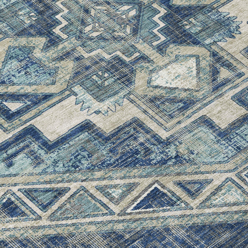Close-up round rug surface with faded Southwestern geometric motif in blues on light base