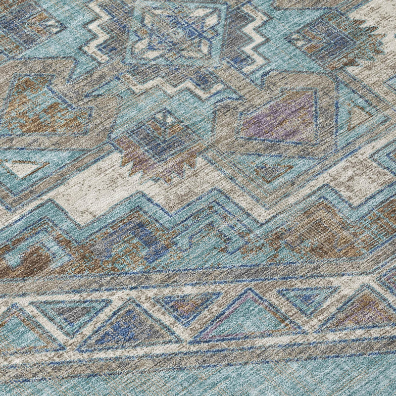 Close-up of teal and gray geometric area rug with distressed Southwestern motifs